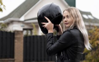 Kvinna som tar på sig en MC-hjälm