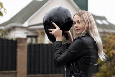 Kvinna som tar på sig en MC-hjälm