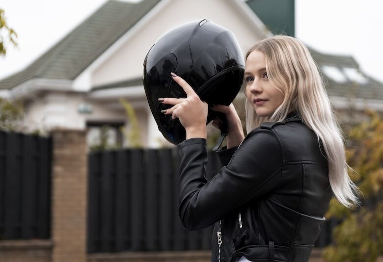 Kvinna som tar på sig en MC-hjälm